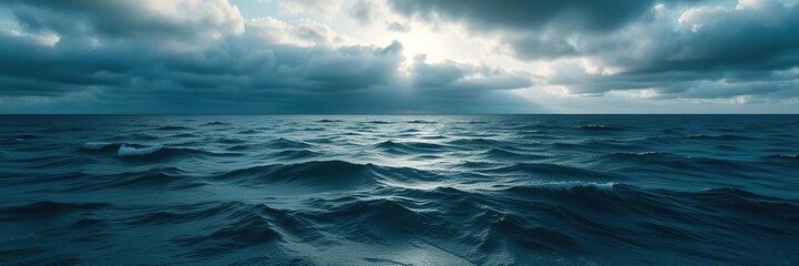 Obraz premium Ocean waves stretch across the vast expanse of the sea as clouds shroud the sun above, cloudy sky, ocean views, wave patterns