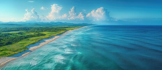 Aerial view of a pristine coastline featuring sandy beaches and azure waves under a clear sky ideal for natural backdrop designs