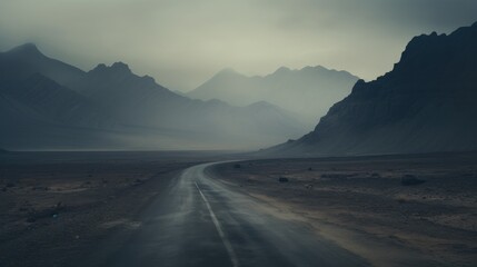 Mysterious road winding through foggy mountains in desolate landscape symbolizing solitude and the spirit of adventure in nature