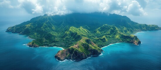 Aerial view of lush green island surrounded by vibrant blue ocean and dramatic cloud formations on a sunny day