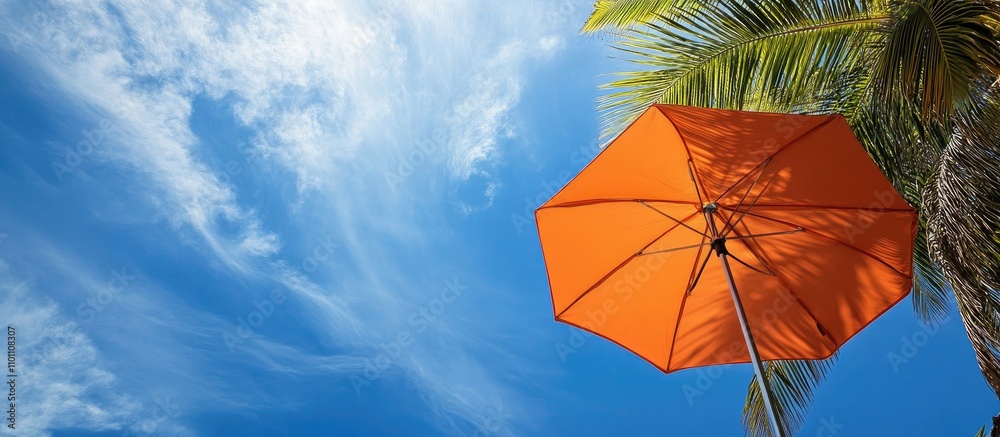 Poster vibrant orange umbrella shading under palm trees against a clear blue sky with wispy clouds in a tro