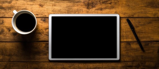 Workspace overhead view with tablet notebook pen and coffee cup on wooden desk emphasizing creativity and productivity in a minimalistic setting