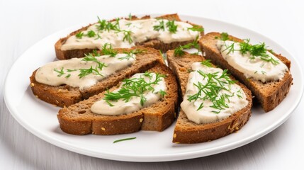Brown bread toasts topped with creamy garlic sauce and fresh herbs on a white plate against a bright background