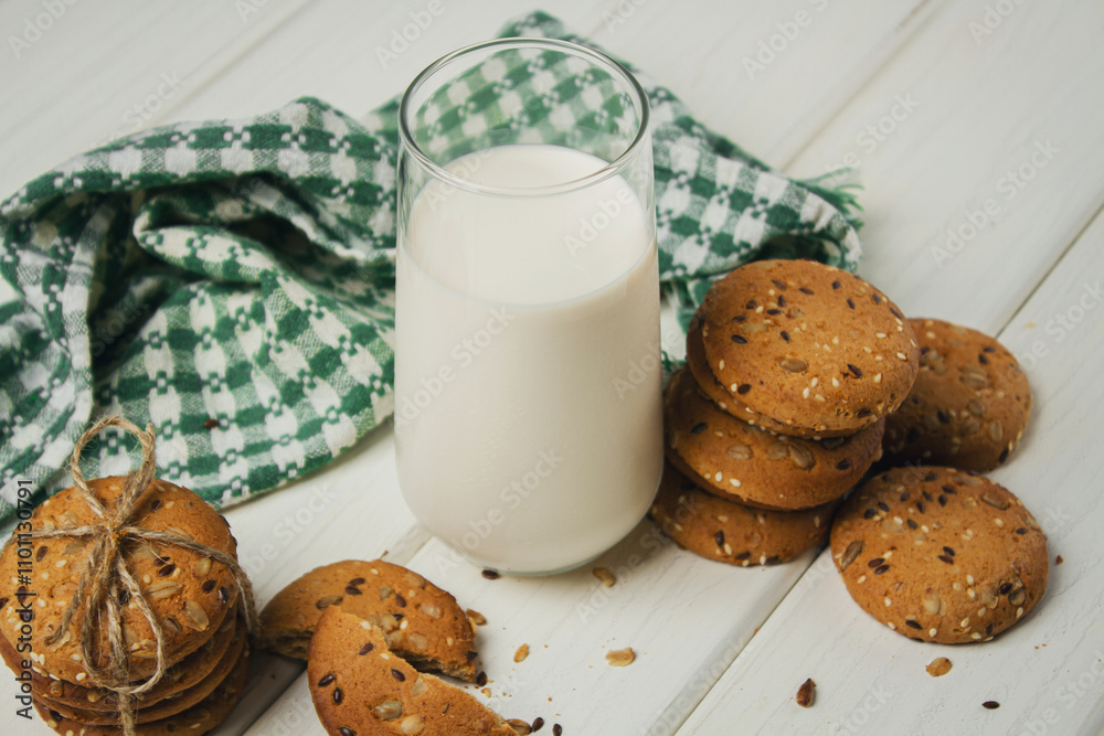 Wall mural Oatmeal cookies with a glass of milk on a light table. Delicious and healthy breakfast