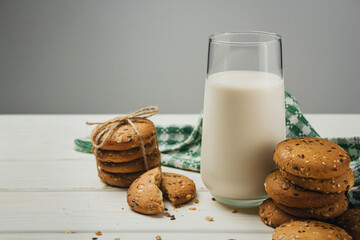 Oatmeal cookies with a glass of milk on a light table. Delicious and healthy breakfast