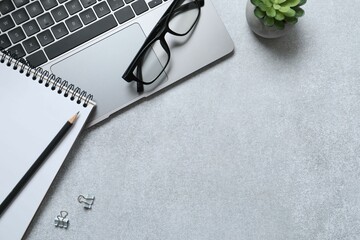 Workplace with laptop, glasses and notebook, top view 