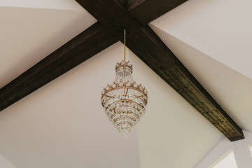 Golden Crystal Chandelier hanging in a rustic room