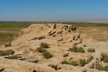 A desert landscape with a large stone structure in the middle