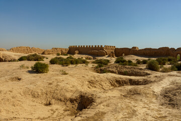 A desert landscape with a large wall in the distance