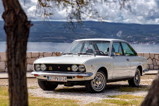Omis, Croatia - August 31st, 2023 - Classical Fiat 124 Sport Coupe on the road. Two-door, four-seater coup&eacute; was based on 124 saloon and its  "Lampredi engine" was designed by ex-Ferrari engineer.