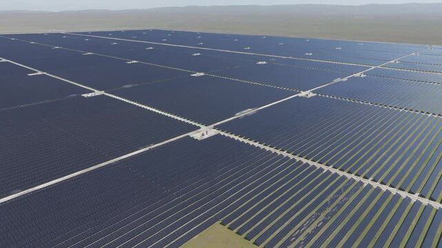 Panoramic aerial drone view of large solar farm amidst green fields