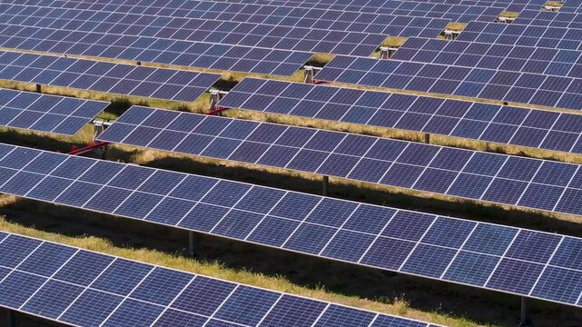 tight aerial push video over solar array rows of panels