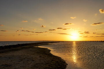 Obraz premium Sun setting over calm waters of the Texas coast.