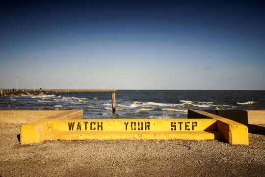 A bright yellow caution sign reads Watch Your Step.