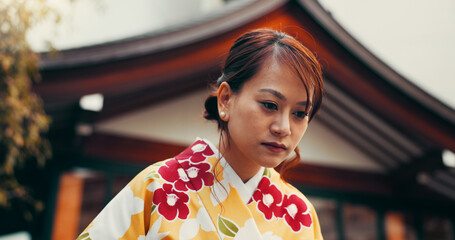 Bow, culture and woman at temple with kimono, fashion and waiting at outdoor building with respect....
