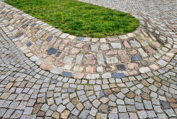 Fototapeta premium A paved island on a raised hill with a lawn on top. It separates lanes and protects the grass from winter salting.