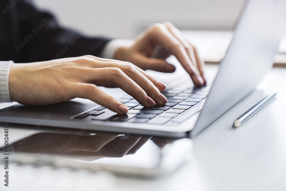 Aufkleber in the blurred setting of an office, a close-up shot captures a woman's hands typing on a modern lap