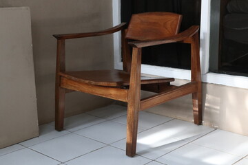 One minimalist wooden chair against an unfinished monochrome wall