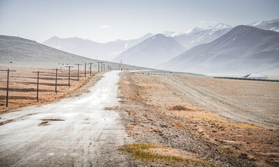 Asphalt road of the Pamir Highway in the valley of the Tien Shan Mountains in Tajikistan in the...