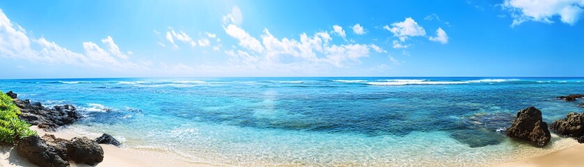 Fototapeta premium A serene beach scene featuring clear blue waters, gentle waves, and a bright sky, creating a tranquil tropical paradise.