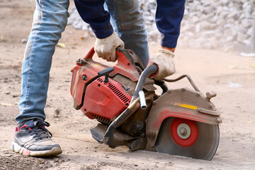 A worker skillfully uses a concrete cutoff saw on a construction site for cutting tasks © Андрей Михайлов