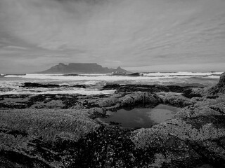 Table Mountain and rocky shoreline in Cape Town.