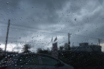 Raindrops on the car glass while driving through heavy rain and storm.