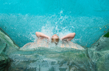 View from above to beautiful young sexy blonde naked woman, enjoying the rippling splashing...