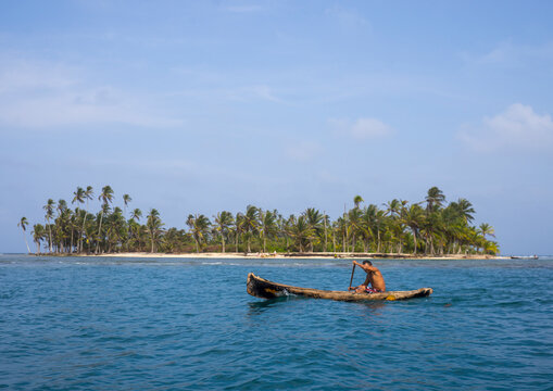Panama, San Blas Islands, Mamitupu, Kuna Indian Man In A Traditional Canoe In Front Of An Island