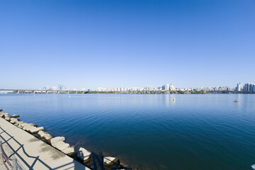 panorama view of the river, Yeouido Hangang River Park, in Seoul, Korea, with a broad bridge, and a cityscape in the backdrop