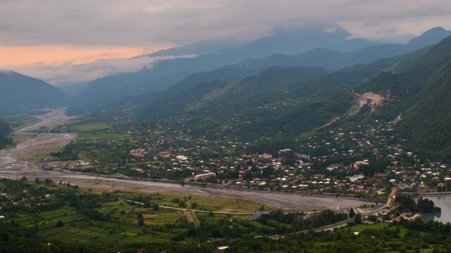 Tsageri, Georgia. Aerial view of a small town Tsageri, Georgia hidden among the mountains. Time-lapse at the sunset with beautiful clowds