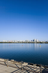 Obraz premium panorama view of the river, Yeouido Hangang River Park, in Seoul, Korea, with a broad bridge, and a cityscape in the backdrop