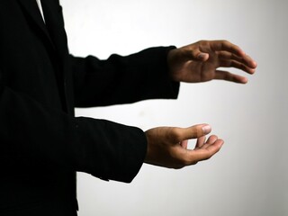 Obraz premium A confident hand in a sleek black suit gestures animatedly, illustrating a strategic business concept such as focus, collaboration, goal setting, time management, networking, emphasizing collaboration