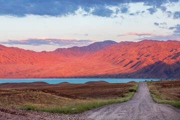 Obraz premium Morning road through the mountainous terrain to Lake Bartogay in Almaty region, Kazakhstan. Amazing nature of Central Asia.