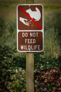 Do Not Feed Wildlife sign in rural landscape on a trail, Oregon, USA