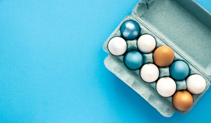 Colored  Easter eggs blue and azure in carton eggs tray background, poster, banner, layout space...