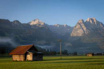 Berglandschaft mit Wiese und Scheune 