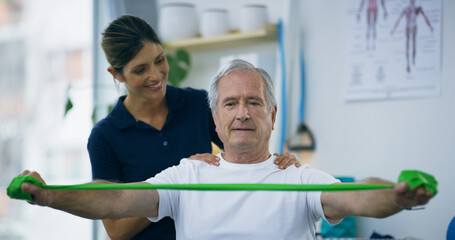 Resistance band, senior man and physiotherapist in office, consultation or recovery. Employee, physical therapy or client with healthcare, wellness or healing with rehabilitation or strength training