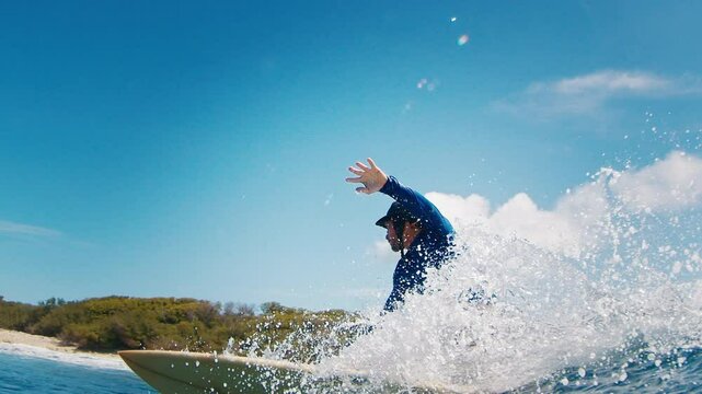 Adult male surfer rides the wave and makes perfect sharp turn with spray. Tropical surfing in the Maldives