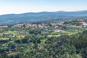 Fototapeta premium Field with trees and agricultural fields in aerial view with church towers in the village of Pedrogão Grande, PORTUGAL