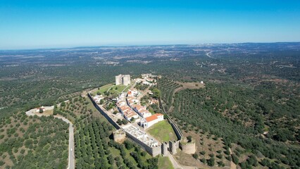 Obraz premium Aerial view of Evoramonte Castle and surrounding landscape in Alentejo, Portugal, under a blue sky