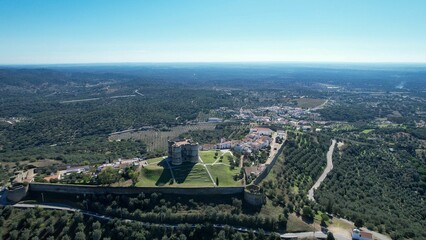 Aerial view of Evoramonte Castle and surrounding landscape in Alentejo, Portugal, under a blue sky