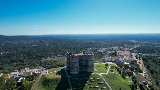 Aerial view of Evoramonte Castle and surrounding landscape in Alentejo, Portugal, under a blue sky