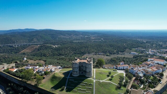 Aerial view of Evoramonte Castle and surrounding landscape in Alentejo, Portugal, under a blue sky