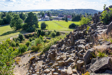 Majestic basalt mountains from which trees grow. Rod-shaped hexagonal stone mountains in the...
