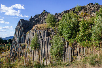 Majestic basalt mountains from which trees grow. Rod-shaped hexagonal stone mountains in the...