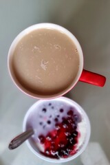 coffee in a red cup and yogurt with red berries