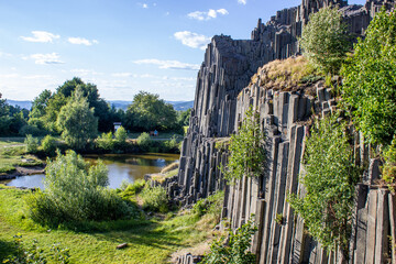 Majestic basalt mountains from which trees grow. Rod-shaped hexagonal stone mountains in the...