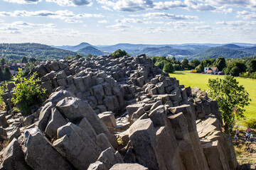 Majestic basalt mountains from which trees grow. Rod-shaped hexagonal stone mountains in the...