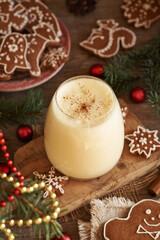 A glass of eggnog with gingerbread cookies and Christmas decoration